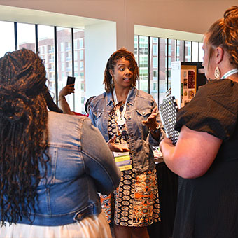 Three woman talking in front of poster boards. Read about Gifts That Pay You Income Three woman talking in front of poster boards. Read about Gifts That Pay You Income