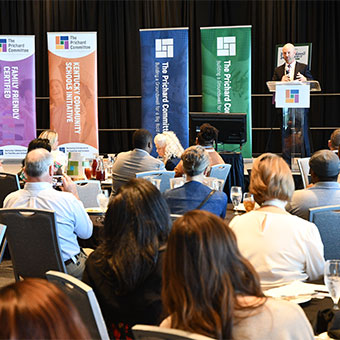 Speaker at podium during a conference. Read about Gifts by Will Speaker at podium during a conference. Read about Gifts by Will